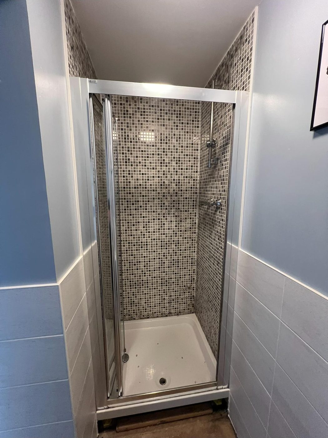 Bathroom in Exeter before renovation — old dated grey mosaic shower
