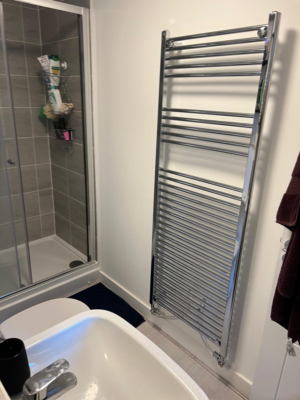 Bathroom in Exeter after — tall chrome heated towel rail over the bath