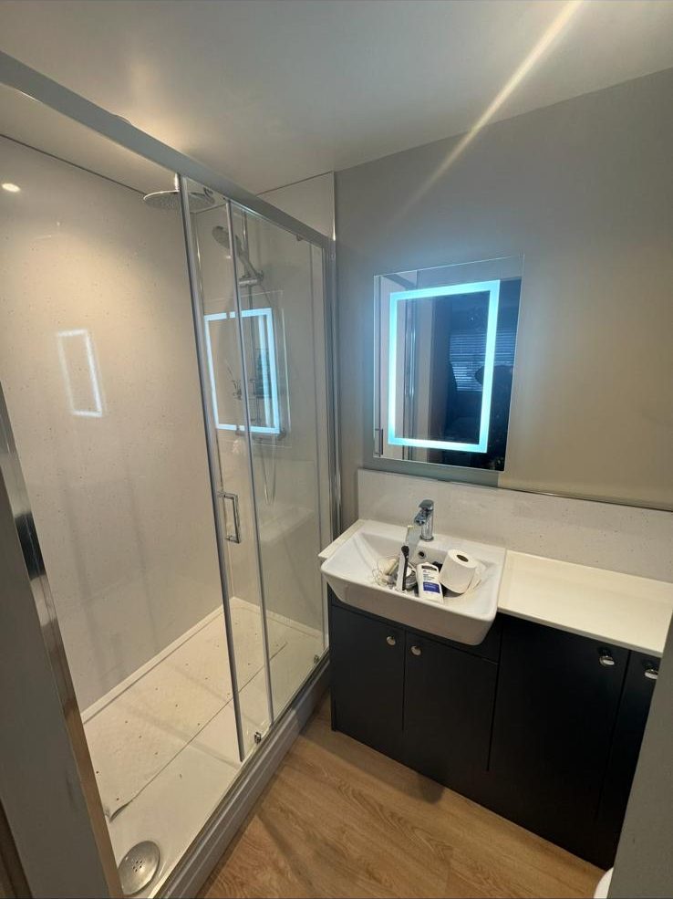 Modern bathroom fitted in Exeter with black vanity and LED mirror