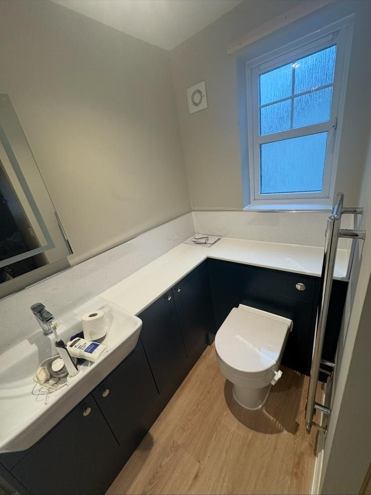 Modern bathroom in Exeter with wood-effect floor and black units