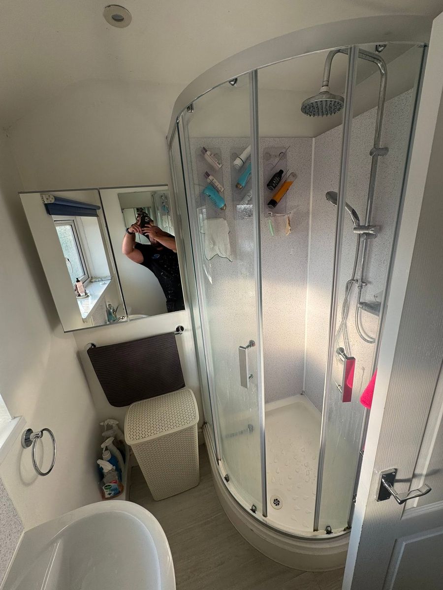 Cloakroom with grey vanity unit and black heated towel rail