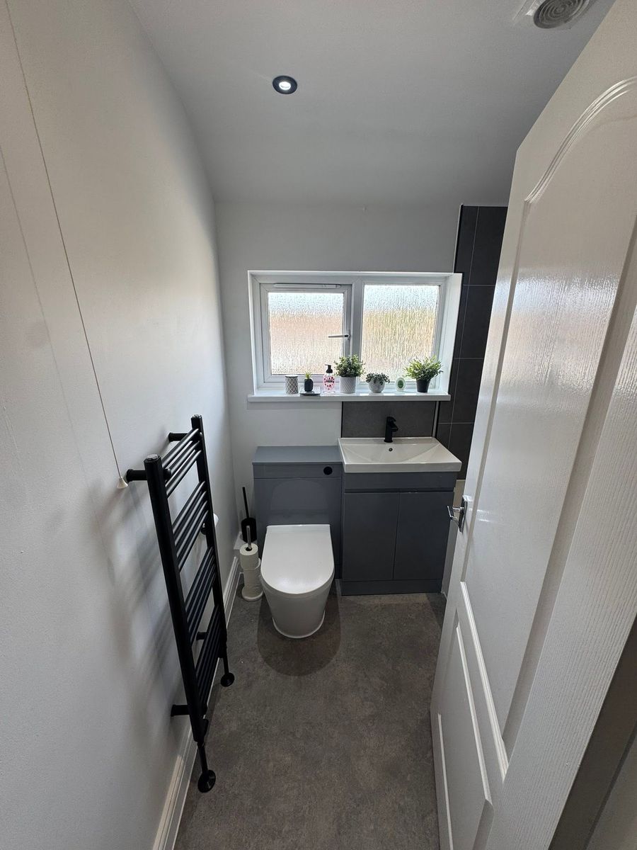 Cloakroom with white basin and wood-effect flooring