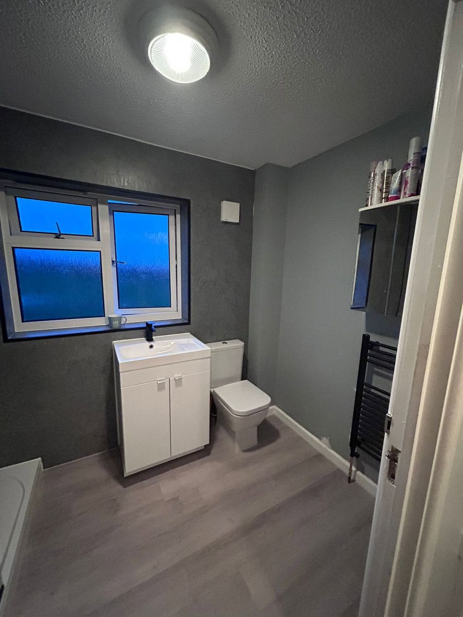 Grey bathroom with white vanity unit and toilet