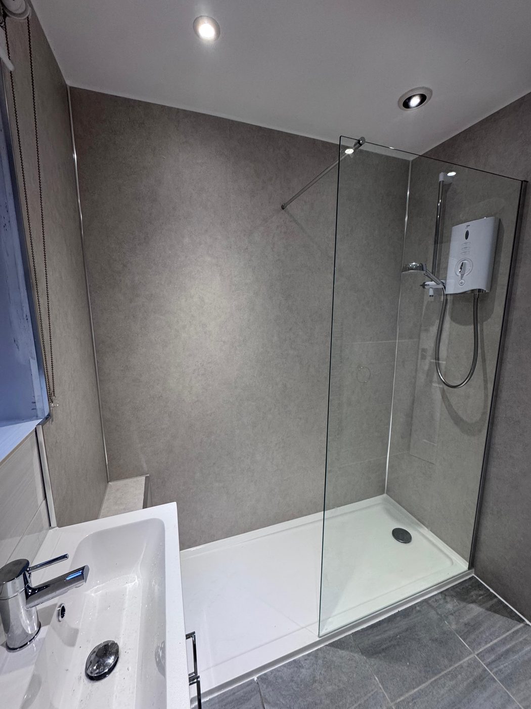 Grey walk-in shower with electric shower fitted in Exeter